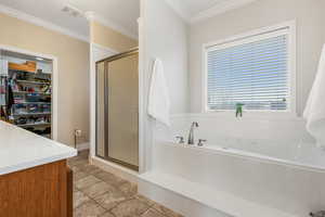 Bathroom with tile patterned floors, vanity, ornamental molding, and plus walk in shower