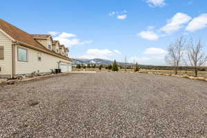 View of yard with a mountain view, a garage, and central air condition unit