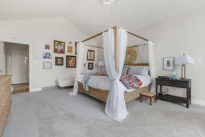 Carpeted bedroom featuring lofted ceiling