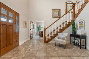 Tiled foyer featuring a high ceiling and crown molding