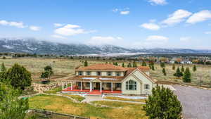 View of front facade with a mountain view, covered porch, and a front yard