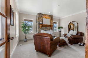 Living room with a healthy amount of sunlight, light colored carpet, and ornamental molding