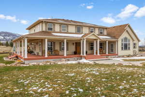 View of front facade featuring covered porch, a mountain view, and a yard