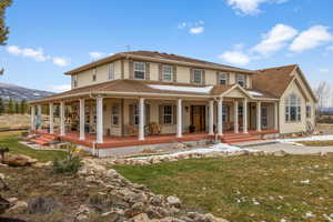 View of front of house with a mountain view, a front lawn, and a porch