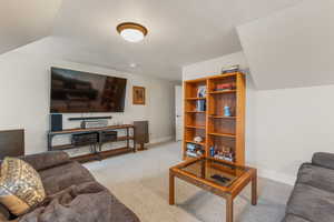 Carpeted living room with lofted ceiling