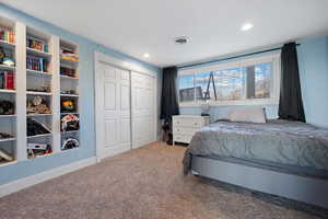 Carpeted bedroom with a closet