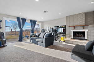 Carpeted living room featuring a brick fireplace