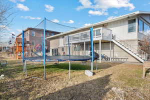 Back of property featuring a playground and a trampoline