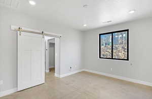 Unfurnished bedroom with a barn door