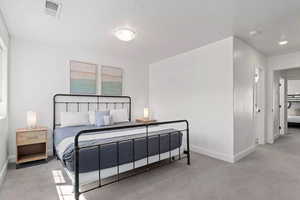 Carpeted bedroom featuring a textured ceiling