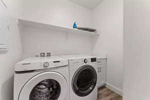 Washroom featuring cabinets, independent washer and dryer, and light hardwood / wood-style flooring