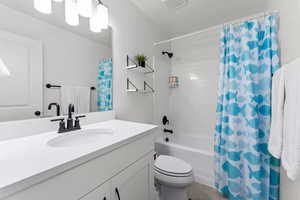 Full bathroom featuring vanity, toilet, and shower / bath combo with shower curtain