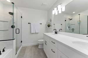 Bathroom with vanity, wood-type flooring, a shower with shower door, and toilet