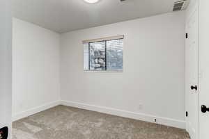 Unfurnished room featuring light carpet