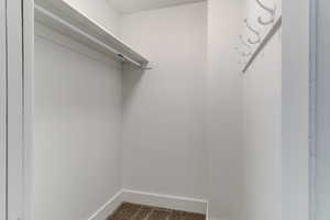 Walk in closet with dark colored carpet