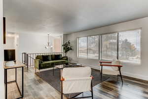 Living room featuring a chandelier, light hardwood / wood-style floors, and plenty of natural light