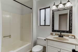 Full bathroom featuring vanity, toilet, and tub / shower combination