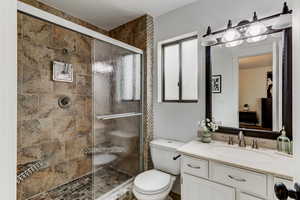 Bathroom with vanity, toilet, and walk in shower