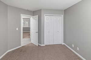 Unfurnished bedroom with a closet and light colored carpet