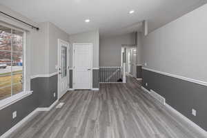 Entrance foyer featuring hardwood / wood-style floors and vaulted ceiling