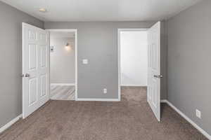 Unfurnished bedroom featuring light colored carpet and a textured ceiling