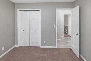 Unfurnished bedroom featuring carpet floors and a closet