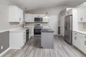 Kitchen with pendant lighting, sink, a kitchen island, and stainless steel appliances