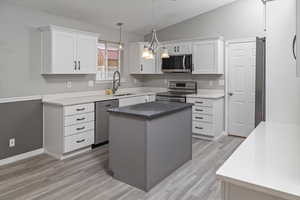 Kitchen with a center island, white cabinetry, sink, and appliances with stainless steel finishes