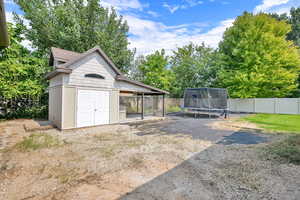 View of yard featuring an outdoor structure and a trampoline