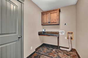 Laundry room with hookup for an electric dryer and cabinets