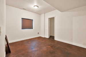 Unfurnished room featuring a textured ceiling