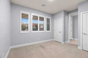 Unfurnished bedroom with light carpet