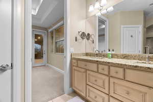 Bathroom with tile patterned floors, vanity, and an inviting chandelier