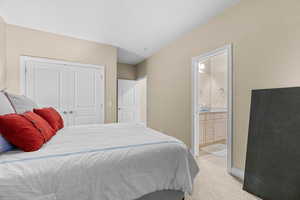 Carpeted bedroom featuring connected bathroom and a closet