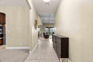 Hall featuring beamed ceiling, light colored carpet, and coffered ceiling