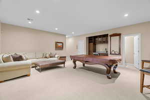 Recreation room with bar, light carpet, and billiards