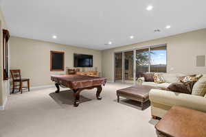 Recreation room with light carpet and pool table