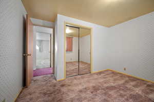 Unfurnished bedroom featuring a closet and carpet