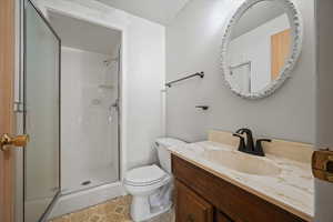 Bathroom with tile patterned flooring, vanity, toilet, and walk in shower