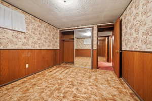 Interior space with light carpet, a closet, and a textured ceiling