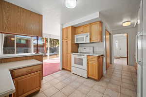 Kitchen featuring white appliances and light tile patterned floors