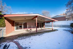 Snow covered property featuring a patio area