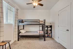 Carpeted bedroom featuring ceiling fan