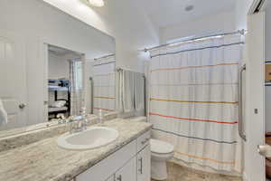 Full bathroom with vanity, toilet, and shower / bath combo with shower curtain