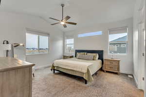 Carpeted bedroom with vaulted ceiling and ceiling fan