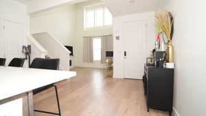 Foyer entrance featuring a towering ceiling and light hardwood / wood-style floors