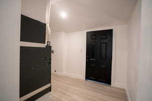 Foyer with a textured ceiling and light wood-type flooring