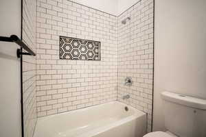 Bathroom featuring toilet and tiled shower / bath