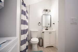 Bathroom featuring toilet, vanity, and hardwood / wood-style flooring