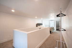 Hall with light carpet and a textured ceiling